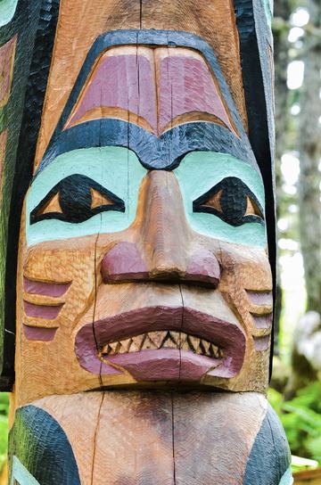 Fine Art photography example: Carved faces older than the forest around them.